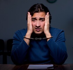 Poster - Young convict man sitting in dark room