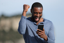 Man With Black Skin Celebrating Checking Phone