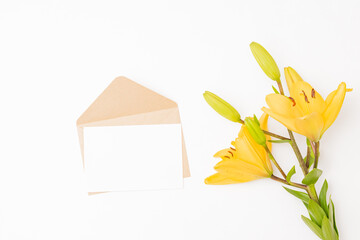 Wall Mural - mockup white wedding invitation and envelope with yellow lilies on white background