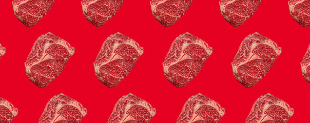 Wall Mural - Pattern made of raw meat beef marbled prime cut steak Ribeye on red clean background from above, minimalist beefsteak concept 