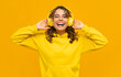 © mary_markevich - smiling attractive woman listening to music in headphones on yellow background
