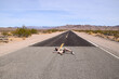 A man pretending to lay in the middle of a highway in the Death Valley