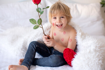 Sticker - Beautiful blond toddler child, boy with lipstick kisses on his body, holding red rose for Valentine