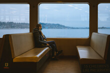 Female Commuter Sitting On A Ferry Boat With A View Of Puget Sound