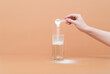 © miss.lemon - Woman pours collagen powder or protein in a glass of water on a beige background. A healthy and anti aging supplement.