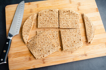 Canvas Print - Cutting Whole Grain Flatbreads into Squares: Cutting flatbread into squares on a bamboo cutting board