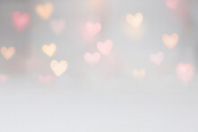 Valentine Background Mockup With Pink And Yellow Heart Shaped Light Bokeh On A Grey Seamless Backdrop. Use For Digital Product Mockup Placement Or As A Background For Text.