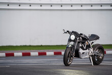 Electric Motorcycle Parked Against A White Wall In Bangkok