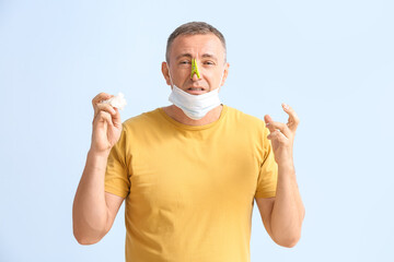 Sticker - Stressed ill mature man with clothespin on his nose against color background