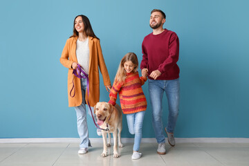 Canvas Print - Happy parents with little daughter and cute Labrador dog near blue wall