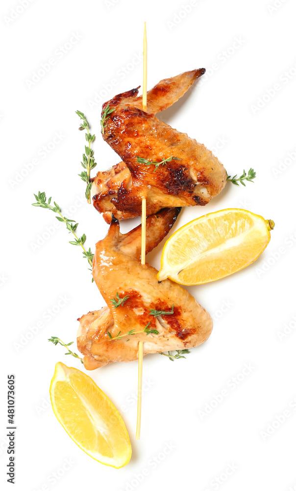 Grilled chicken wings skewer with lemon and thyme on white background