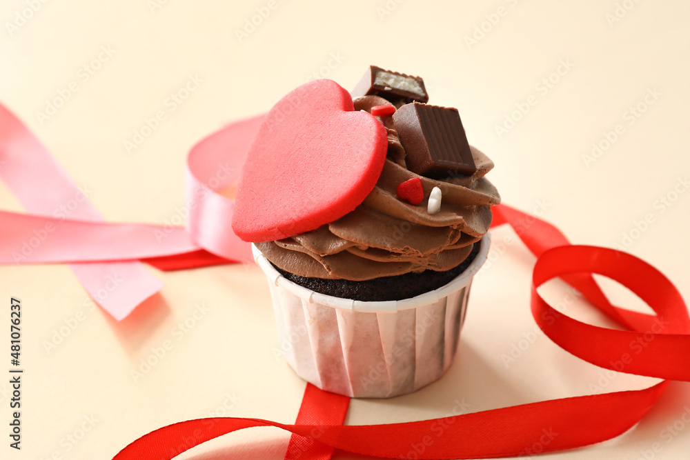 Tasty chocolate cupcake for Valentine's Day on beige background
