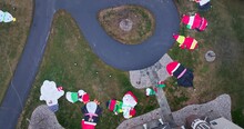 Top Town Of Inflatable Christmas Decorations Laying On Lawn Grass Yard. Aerial View At Holiday Season In Winter.
