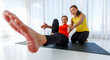 © Bangkok Click Studio - Asian coach supporting woman during yoga session