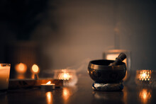 A Close-up Of A Tibetan Bowl With Blurred Background Candles And Also A Plant. Photo Taken In A Spiritual And Mystical Tone After A Yoga Session.