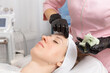 © BY-_-BY - Beautician removes a clay mask from the face of a young woman in the Spa salon.