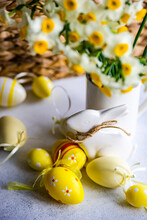 Easter Bunny Ornament And Painted Easter Eggs Next To A Bunch Of Narcissus Flowers In A Jug