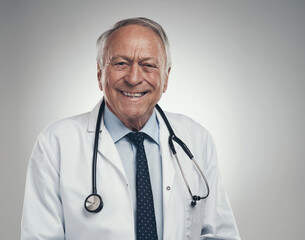 Wall Mural - making my way through the hospital. Shot of a happy elderly male doctor in the studio against a grey background.