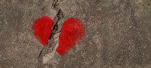 Red Heart Painted On A Concrete Wall And Cracked In Two. Copy Space For Additional Content.