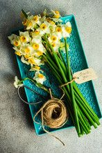 Overhead View Of A Bunch Of Narcissus Flowers On A Tray With A Thank You Tag, String And Scissors