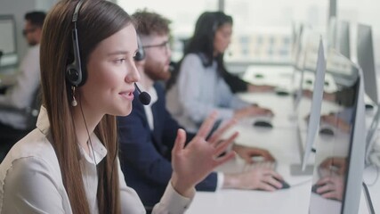 Call Center Office: Portrait of Friendly Caucasian Female Technical Customer Support Specialist Talking on a Headset, Diverse group of workers talks on sale hotline. Busy seller at agency office