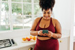 © (JLco) Julia Amaral - Plus size woman texting on smart phone