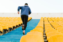 Young Sportsman Running Up The Stairs While Working Out At Stadium