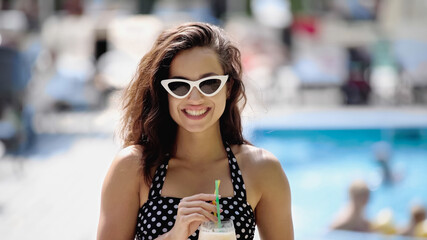 Canvas Print - happy young woman in sunglasses holding cocktail