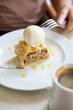 Woman eating apple strudel pie served with vanilla ice cream