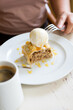 Woman eating apple strudel pie served with vanilla ice cream