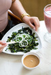 Woman eating healthy green seaweed salad for breakfsat