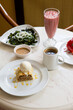 Cafe table with apple strudel pie plate and seaweed salad with smoothie