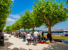 Lovely View Of The Promenade At The Rhine River In Mainz, Germany. People Are Strolling And Looking What The Regular Flea Market Has To Offer On A Sunny Day With A Blue Sky.