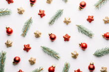 Creative Christmas Background With Christmas Balls, Pine Twigs, Red And Golden Stars Decorations On White Background. Flat Lay, Top View, Copy Space