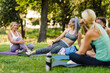 © Drobot Dean - Multiracial women talking and smiling during yoga practice in park