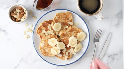 Wall Mural - Banana protein pancakes with almonds and cup of coffee on white marble table background, top view. Sports nutrition