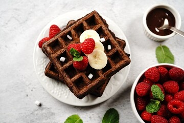 Poster - Chocolate square waffles topped with berries and banana, selective focus