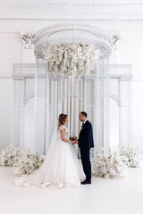 Wall Mural - Newlyweds swear allegiance to each other. Celebration in the White Hall. Congratulations to the young. Significant day.