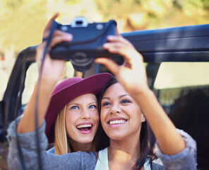 Canvas Print - Picture perfect moments. Shot of a two girlfriends taking self-portraits while on a roadtrip.