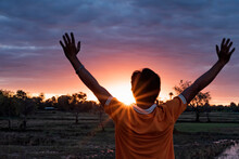 The Silhouette Behind The Young Man Raised His Head. Feel Energized By The Warm Light And Sky.