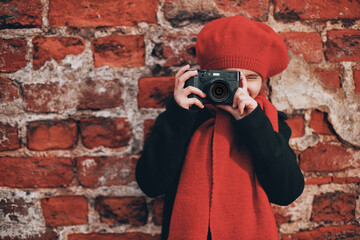 Poster - a girl at a brick wall takes pictures