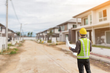 Wall Mural - professional engineer in protective helmet and blueprints paper at the house building construction site