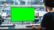 © Gorodenkoff - Close Up Over the Shoulder Shot of a Businesswoman Working on Desktop Computer with Chroma Key Green Screen Mock Up Display. Digital Projects Manager Typing Data, Using Keyboard and Mouse.