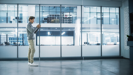 Aufkleber - Handsome Stylish Interior Designer Standing in Empty Modern Office and Map it with an Augmented Reality Software on a Tablet Computer. Architect Planning Out the Floor for Business Company Space.