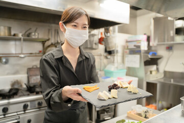 Wall Mural - 感染症対策のマスクをして食事提供する女性スタッフ