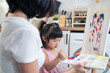 © Kawee - Asian young happy kid daughter coloring on painting board with mother.