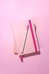 Top view notebooks on pink desktop