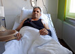 Ein operierter Mann liegt in einem Bett im Krankenhaus
