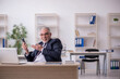 © Elnur - Old male employee sitting at workplace