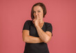 bad smell concept, woman covering her nose with her finger from strong stench on pink background